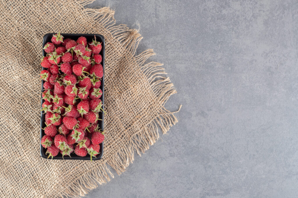 delicious red raspberries black plate high quality photo (1)