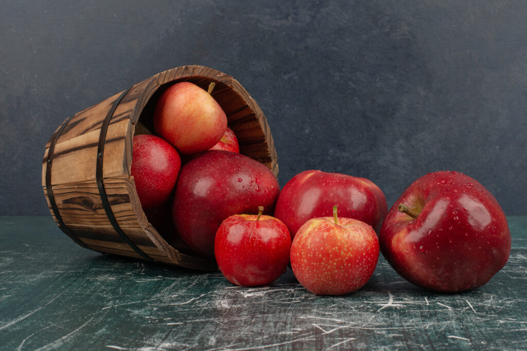 red apples falling out bucket marble table (1)