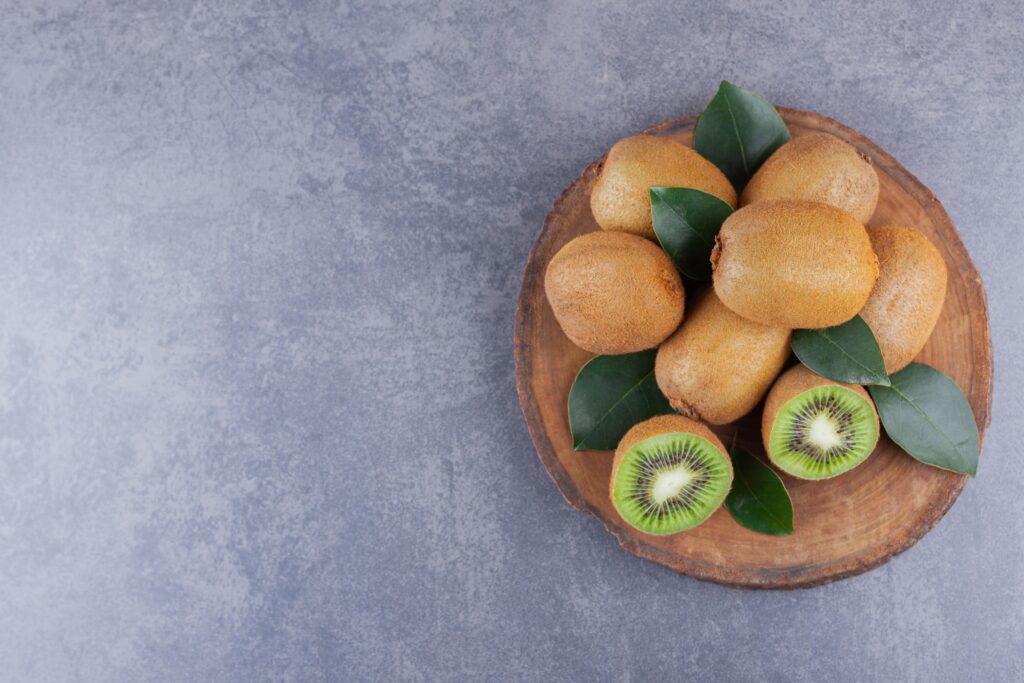 whole sliced kiwi fruit placed stone table (2)